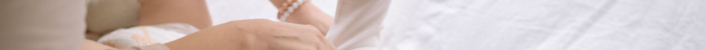 Parent dressing a baby in a long-sleeve onesie for a cold Australian winter night`