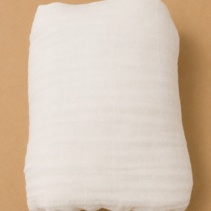 White quilted pillow on a brown background