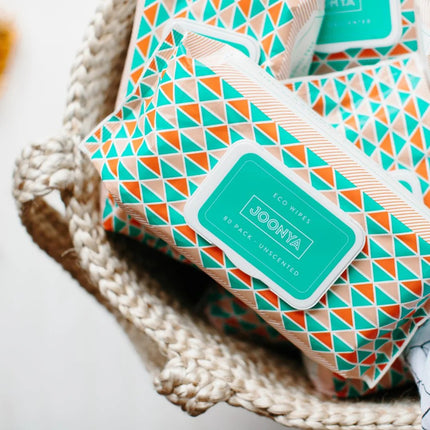 Joonya Natural Baby Wipes 3-pack in a woven basket, features embossed fabric, aloe vera, chamomile, jojoba oil, fragrance-free.