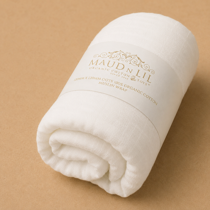 Rolled-up white blanket with 'Maud & Lil' branding on a beige background