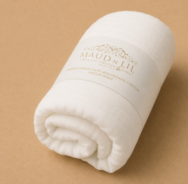 Rolled-up white blanket with 'Maud & Lil' branding on a beige background